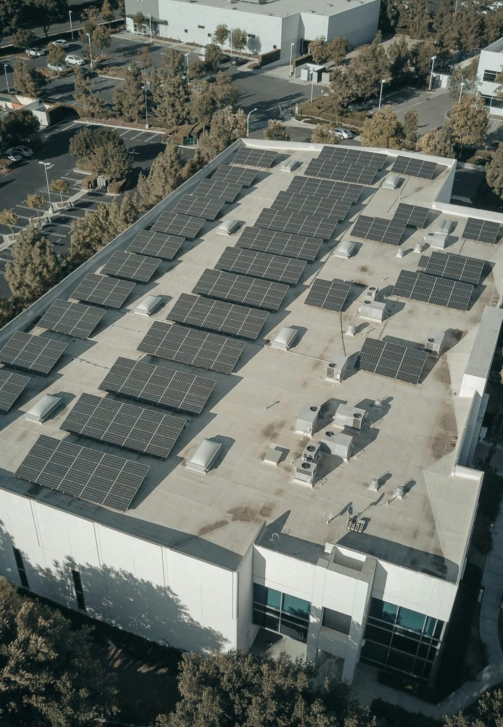 Aerial shot of a commercial building with solar panels, emphasizing renewable energy architecture.
